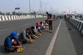 インド・デリーとウッタルプラデシュ州の境の高速道路に座って食事をとる、デモ参加者ら（2020年12月6日撮影）。(c)Prakash SINGH / AFP
