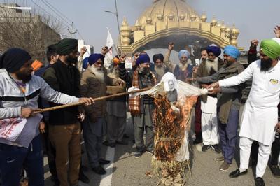 Des agriculteurs brûlent l’effigie du Premier ministre indien Narendra Modi dans la périphérie d’Amritsar, ce 2 février 2021.