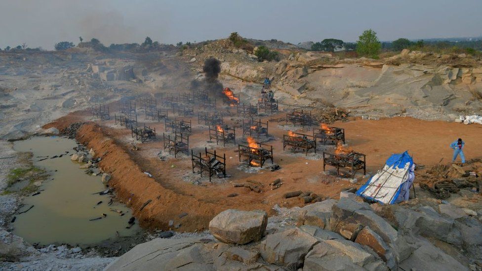 Burning pyres of the victims who died of Covid-19 coronavirus are pictured at an open air crematorium set up for the coronavirus victims inside a defunct granite quarry on the outskirts of Bangalore on May 1, 2021
