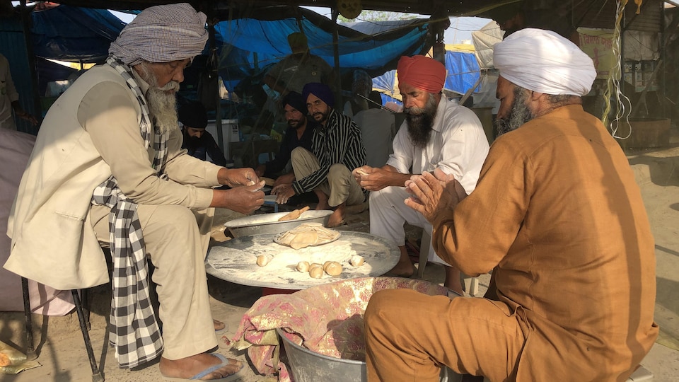 Des hommes fabriquent du pain.