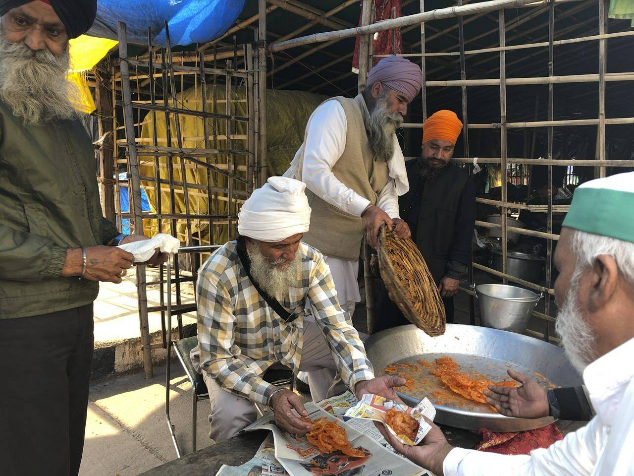 Farmers distribute sweets to celebrate news of the repeal of farm laws they were protesting against, in Ghazipur, on the outskirts of New Delhi, India, Friday, Nov. 19, 2021. Prime Minister Narendra Modi has said his government will withdraw the controversial farm laws that were met with year-long demonstrations from tens of thousands of farmers who said the laws will shatter their livelihoods. The drawn-out demonstrations have posed one of the biggest political challenges to Modi, who swept the polls for the second time in 2019. (AP Photo/Manish Swarup)