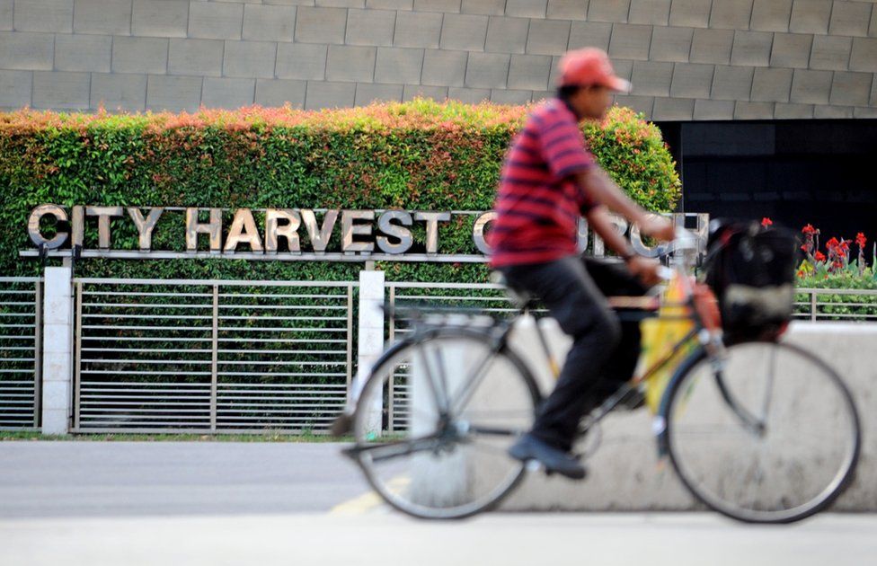 A cyclist rides past the City Harvest Church in Singapore on 26 June 2012.