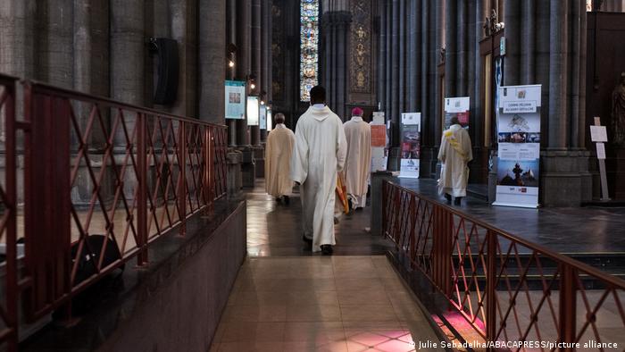 priests walking in church in France